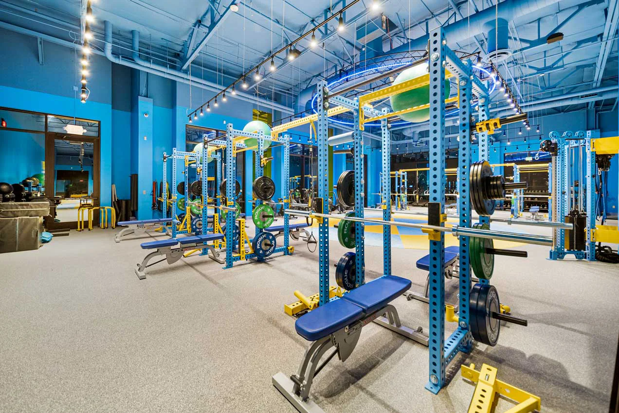 Strength training area at Legacy Personal Training in Scottsdale, AZ featuring squat racks, barbells, and free weights.